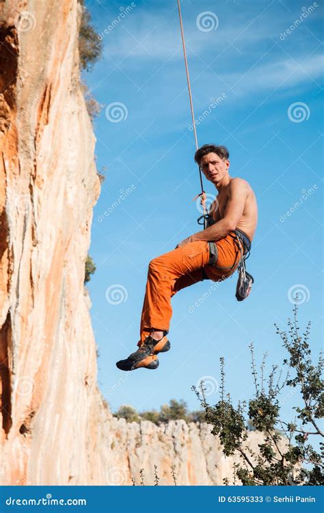 Rock Climber Hanging On Belay Rope Over The Mountains Stock Image