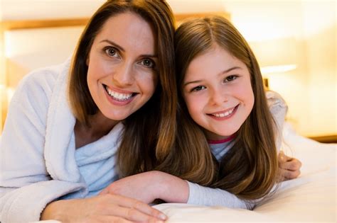 Free Photo Portrait Of Mother And Daughter Lying On Bed