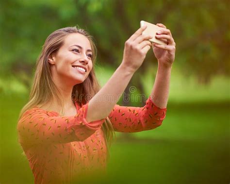 Capturing A Carefree Outdoor Moment A Young Woman Taking A Selfie