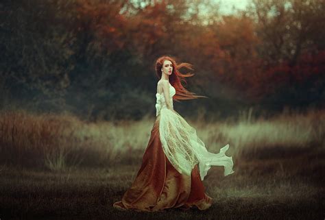 Woman With Long Red Hair In A Golden Medieval Dress Walking Through The