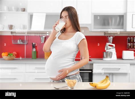 Beautiful Pregnant Woman Drinking Milk At Kitchen Stock Photo Alamy