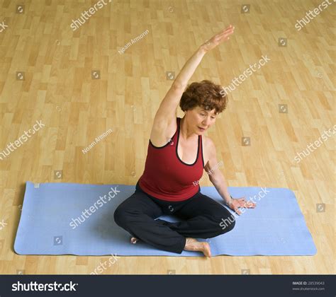 Senior Woman Doing Bikram Hot Yoga In A Gym Stock Photo