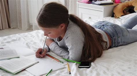 Girl Doing Her Homework On Her Bed Free Stock Video Mixkit