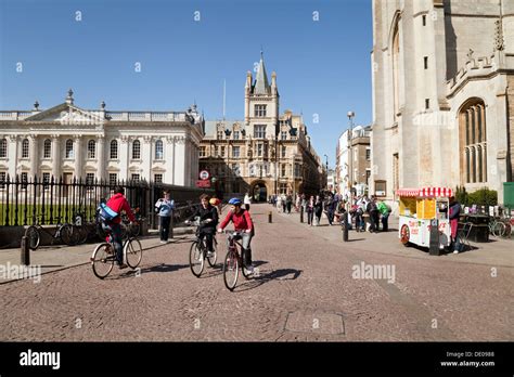 Cyclists In Cambridge City Centre Cycling On Kings Parade On A Sunny