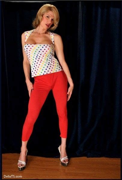 A Woman In Red Pants And Polka Dot Top Posing For The Camera With Her