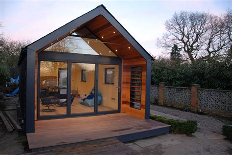 A Small House With Glass Doors And Wooden Flooring In Front Of The