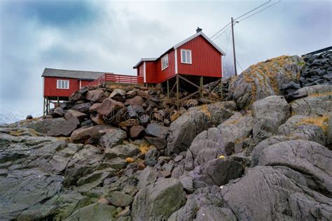 Typical Norwegian Red Houses On Stone Cliffs In The Fjords Stock Photo