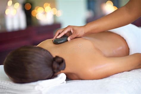 Be Still A Young Woman Enjoying A Hot Stone Massage At A Spa Stock
