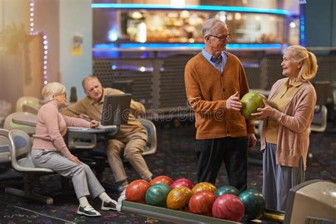 Group Of Smiling Senior People Posing At Bowling Alley Stock Photo