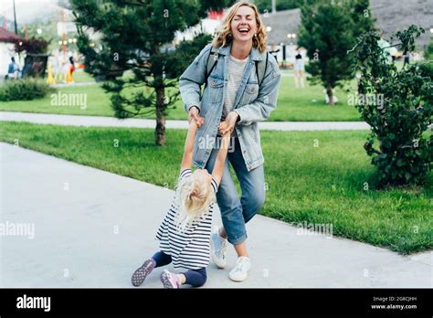 Emotions Of A Mom Fooling Around With A Little Daughter Mom Twirling Her Daughter Outside Stock