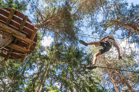 Teenager Having Fun On High Ropes Course Adventure Park Climbing