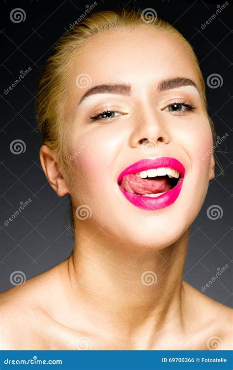 Beautiful Blonde With Colorful Pink Lips Sticking Out Her Tongue Stock