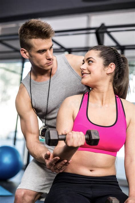 Male Trainer Assisting Woman Lifting Dumbbells Stock Image Image Of