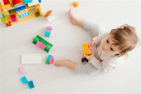 Adorable Child Playing With Multicolored Building Blocks On Floor Stock