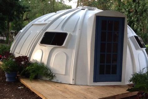 A Large White Dome House Sitting On Top Of A Wooden Platform