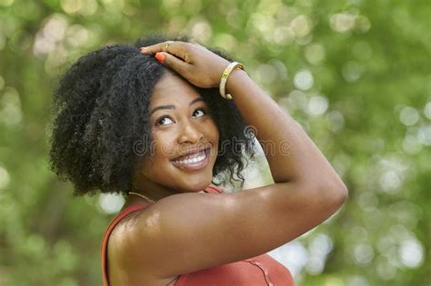 Hermosa Mujer Negra Posa En La Parte Superior De Un Tanque De Naranja Y Falda De Denim Imagen De