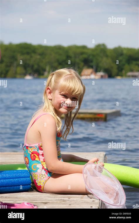 7 Year Old Girl Sitting On Dock With Pool Noodle Gravenhurst Ontario