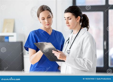 Doctor And Nurse With Clipboard At Hospital Stock Photo Image Of