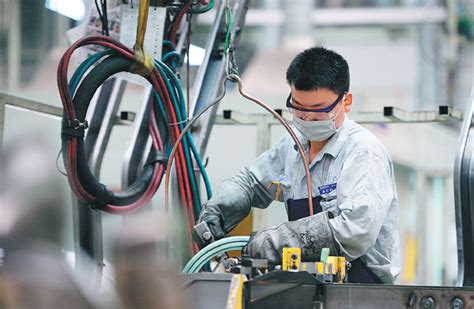 A Worker Performs A Soldering Job At An Auto Manufacturing