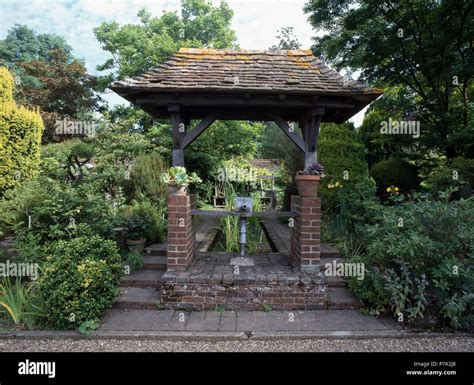 Tiled Roof On Small Brick Gazebo In Large Country Garden With Small