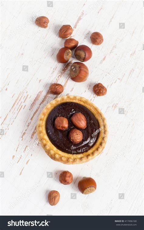 Once mousse has frozen, unmold and prepare on a glazing wrack. Small Tart with hazelnut and chocolate mousse, top view ...