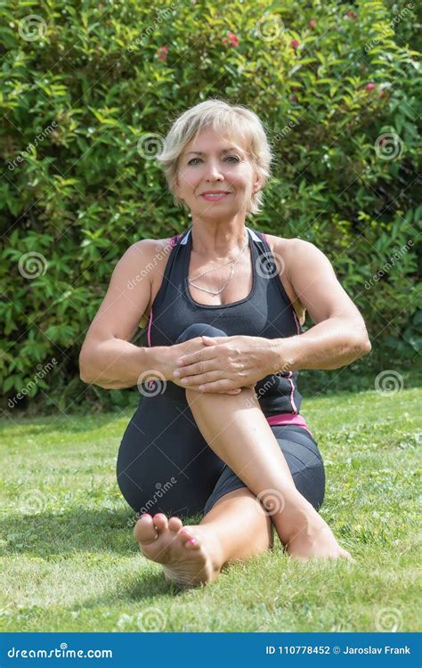Senior Blond Woman Doing Her Stretching Outside Vertically Stock
