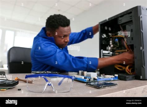 African American Technician Repairing Computer In Service Center Stock