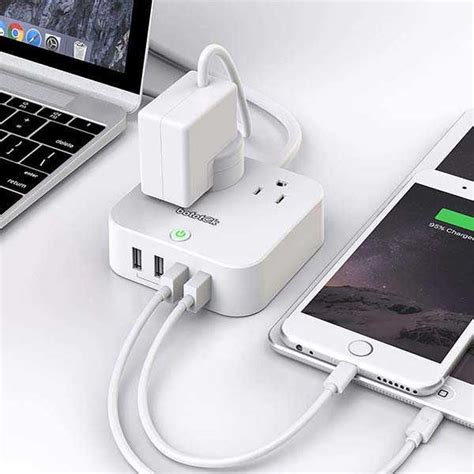 An Iphone And Charger Sitting Next To A Laptop