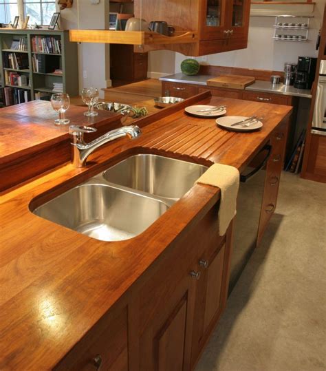 A Kitchen With Wooden Counter Tops And Stainless Steel Sink In Front Of