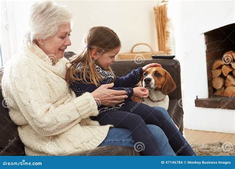 Abuela Y Nieta Que Se Relajan En Casa Con El Perro Casero Foto De