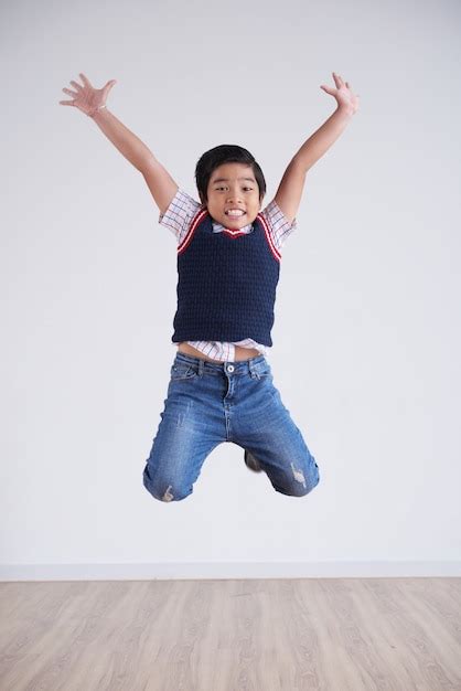 Free Photo Portrait Of Little Boy Jumping Happily High In The Air