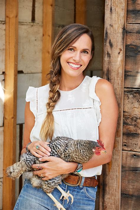Woman Holding Chicken In Her Backyard Chicken Coop By Stocksy