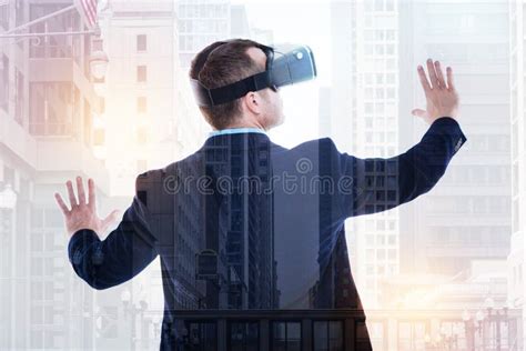 Back View Of Businessman Wearing VR Headset And Spreading Hands Stock