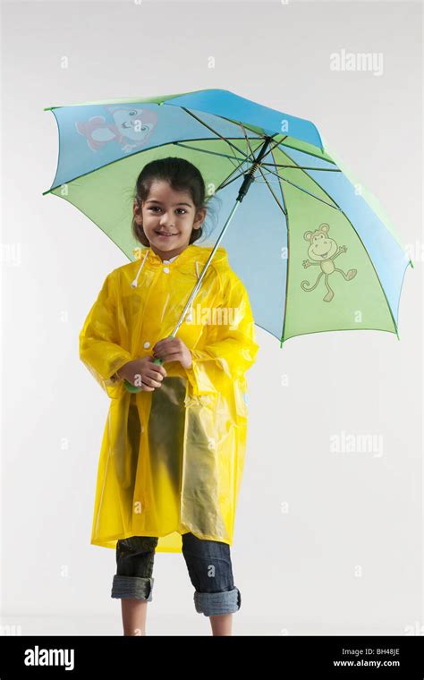 Girl Wearing A Raincoat And Holding An Umbrella Stock Photo Alamy