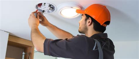 Premium Ai Image Electrician Installing Led Light Bulbs In Ceiling Lamp