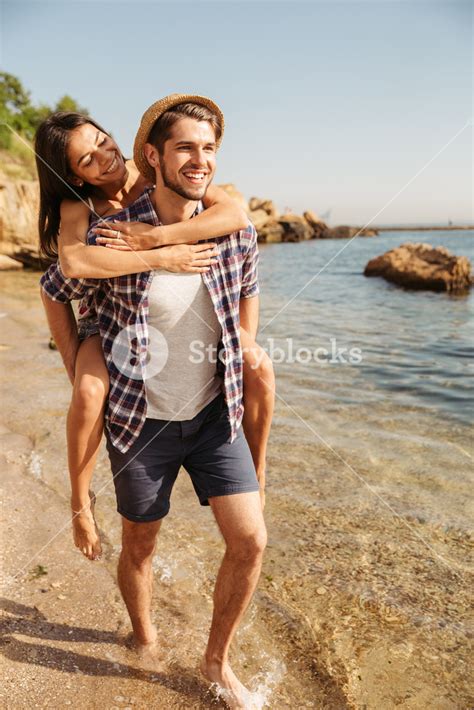 Caring Man Giving A Lift To His Partner At The Beach Royalty Free Stock