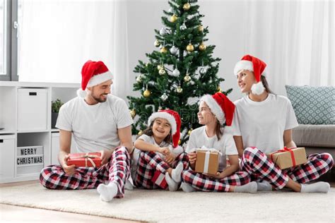 Feliz Familia Abriendo Regalos De Navidad En Casa Imagen De Archivo