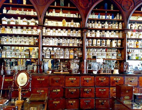 An Old Fashioned Pharmacy Cabinet With Many Bottles On The Wall And