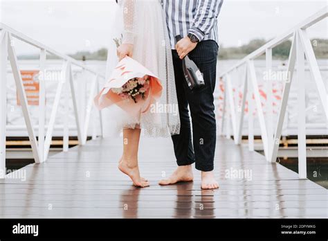 Foots Of The Just Married On The Wharf Legs Of The Bride And Groom Barefoot On The Pier Stock