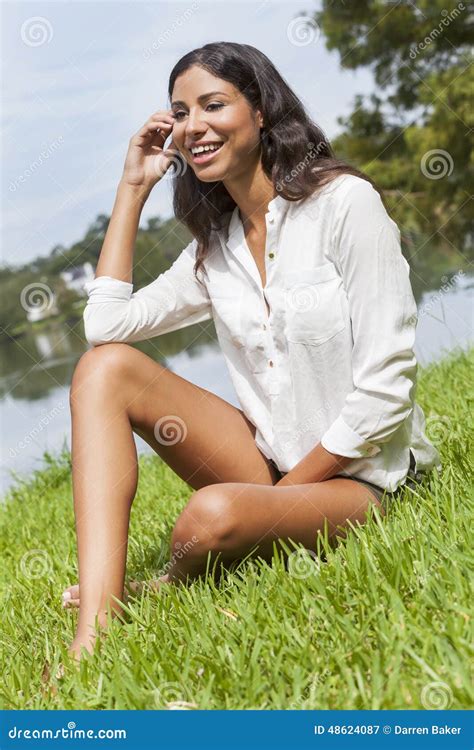 Latina Woman Girl Sitting On Grass By Lake In Summer Stock Image