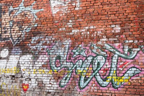 Urban Brick Wall With Grungy Chaotic Graffiti Editorial Stock Photo