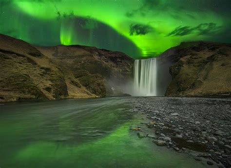 A Flash Of The Northern Lights Aurora Above The Skogafoss Waterfall In