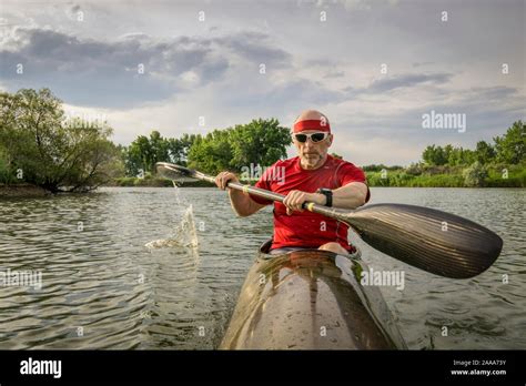 senior male paddler is paddling a long, narrow and fast racing sea