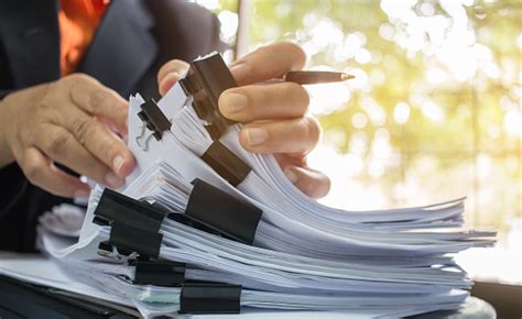 Businessman Hands Working In Stacks Of Paper Files For Searching