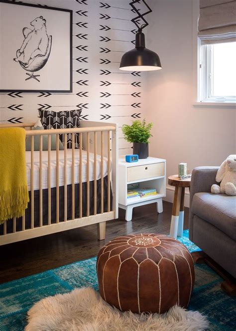 A modern gender neutral nursery with a grey paneled wall, a wooden sideboard, a black crib and a catchy chandelier. All the Inspiration You Need to Craft a Gorgeous Gender-Neutral Nursery | Modern nursery design ...