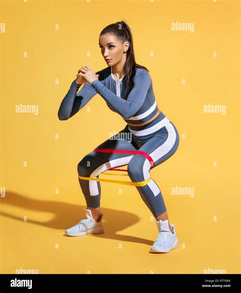 sporty woman squatting doing sit ups with resistance band photo of latin woman in fashionable