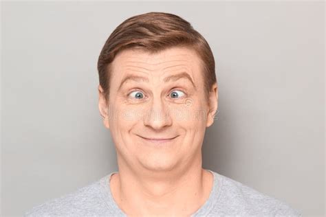 Portrait Of Funny Happy Man Making Goofy Face With Crossed Eyes Stock