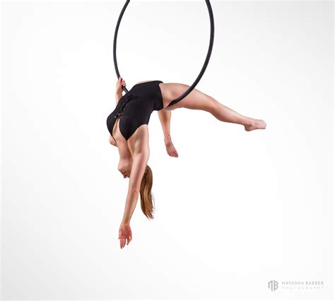 A Woman Is Doing Aerial Acrobatics With A Hoop On Her Head And Legs