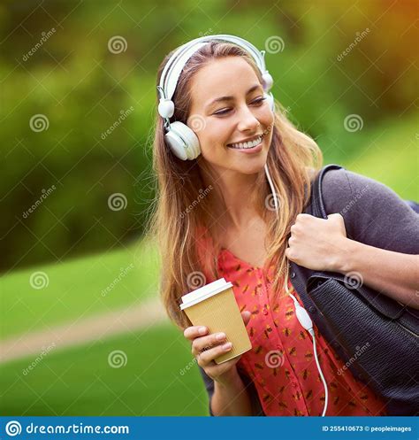 Strolling Through The Park With Her Coffee And Music A Young Woman