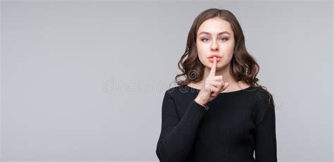 Beautiful Serious Young Woman Holding Finger At Her Lips Saying Shh
